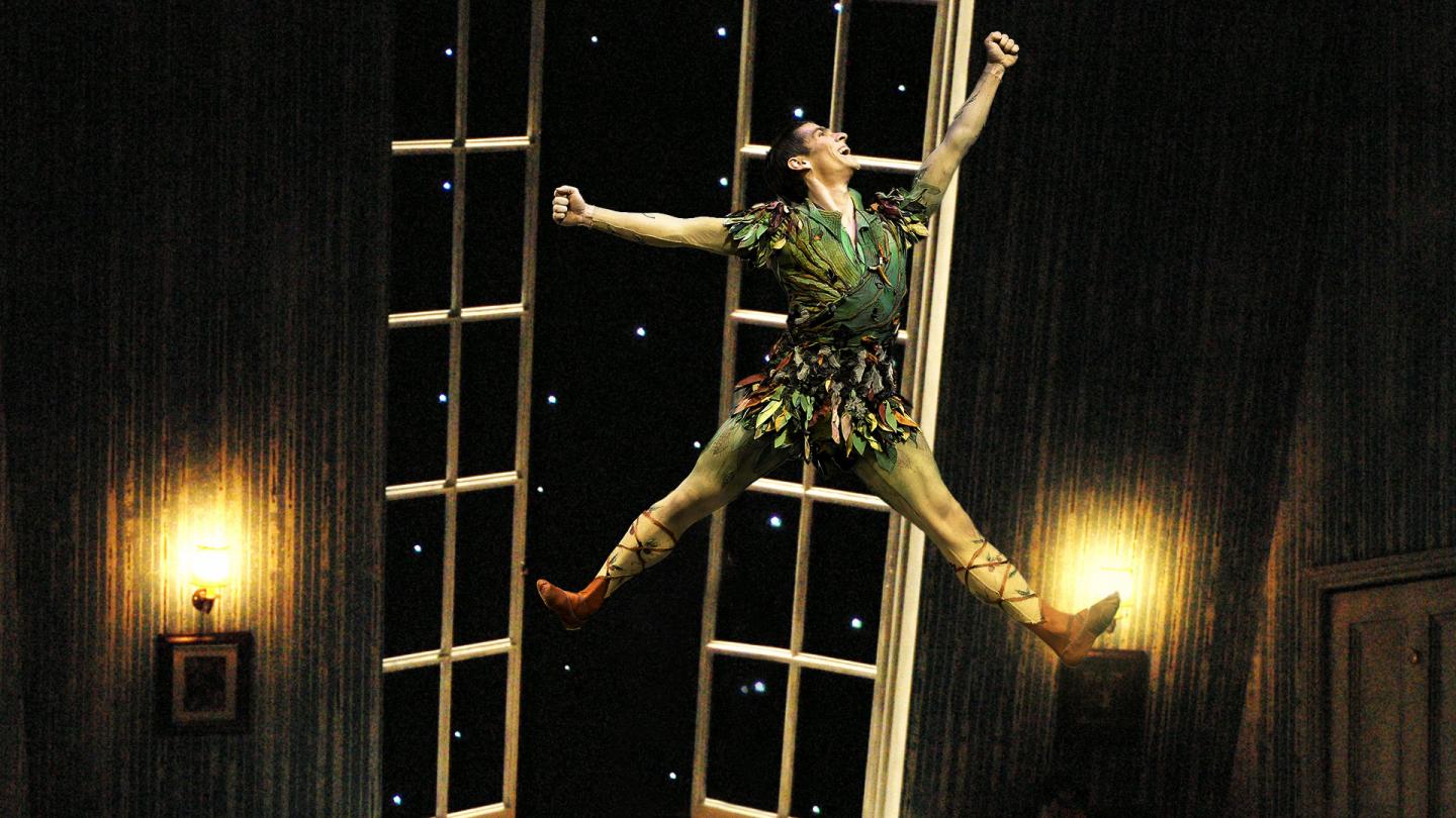 Ashley Dixon as Peter Pan leaps high in the Darling children's bedroom