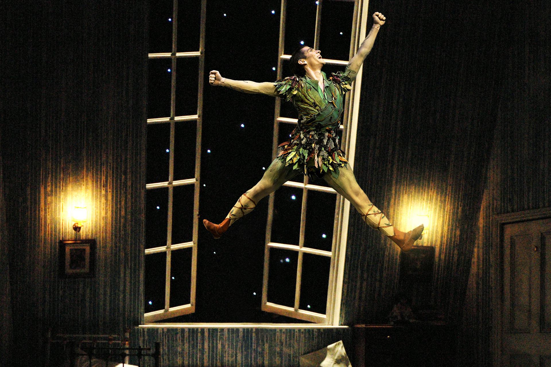 Ashley Dixon as Peter Pan leaps high in the Darling children's bedroom