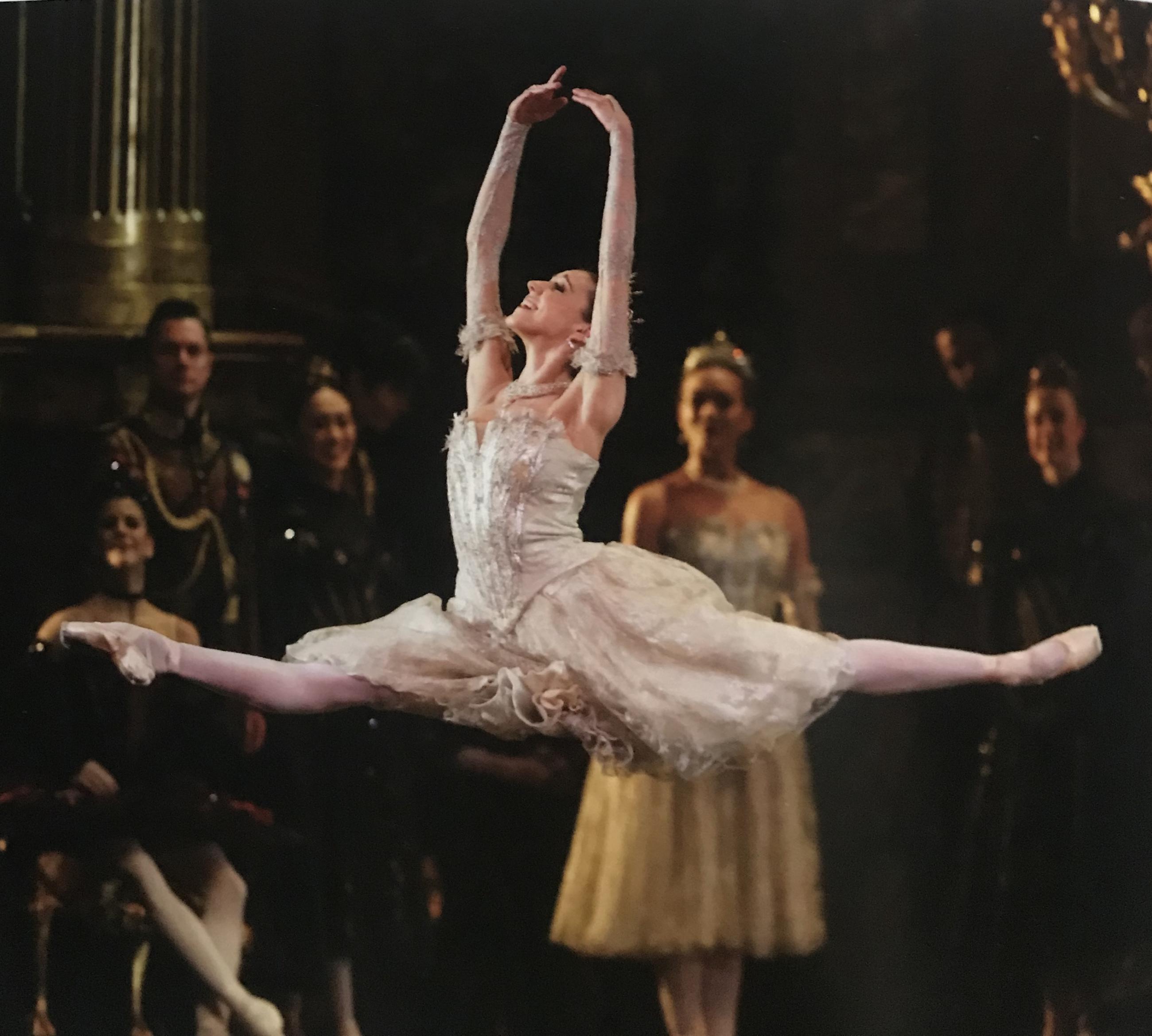 Isabella Gasparini performing a grand jeté on stage at The Royal Opera House.