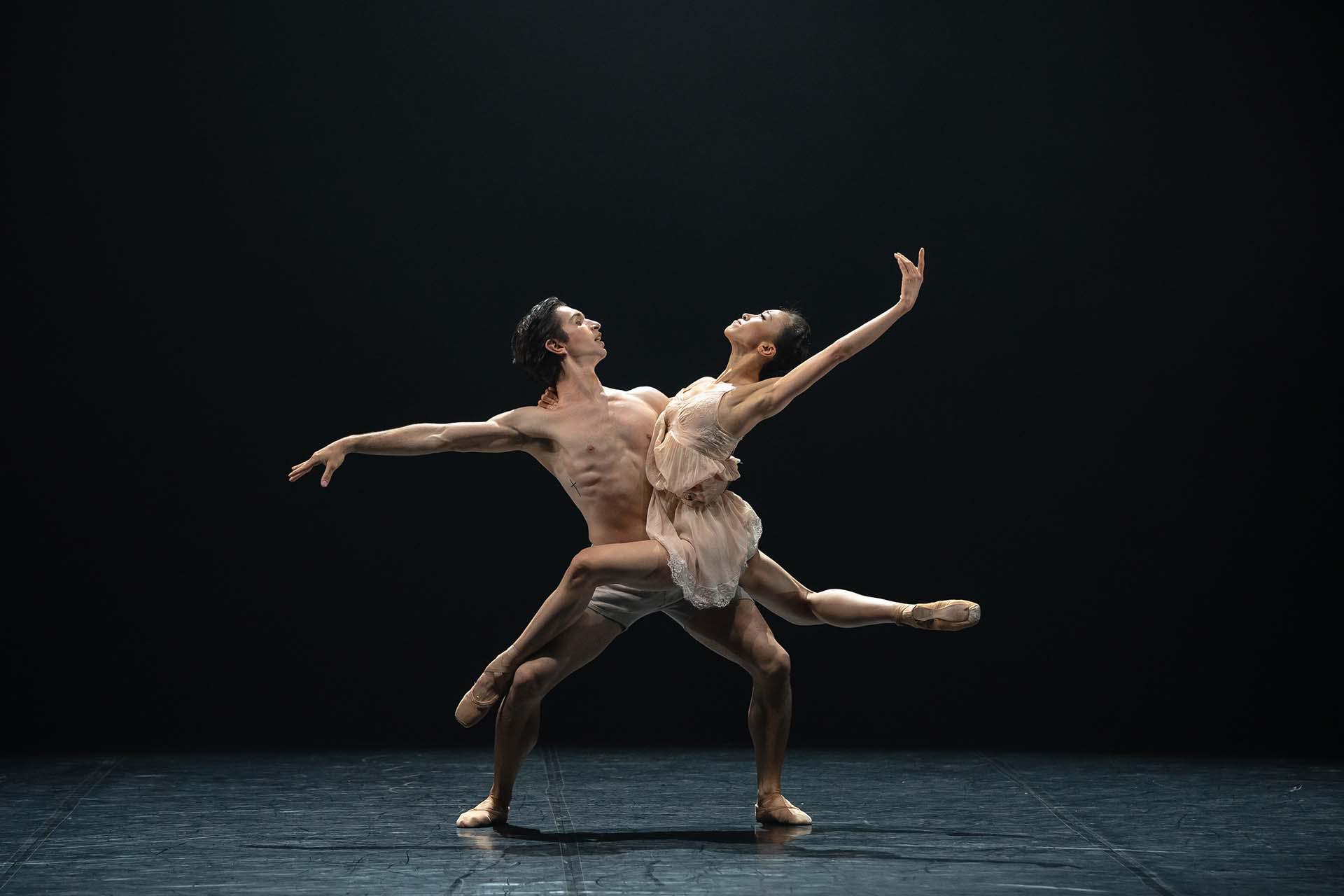 Julia and Winston hold each other while reaching back