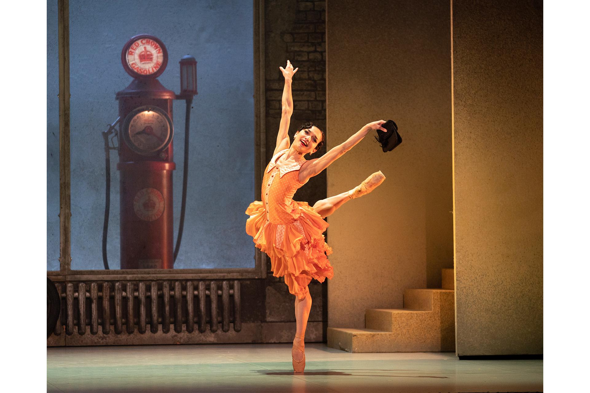 Myrtle in her orange dress dancing happily through the garage