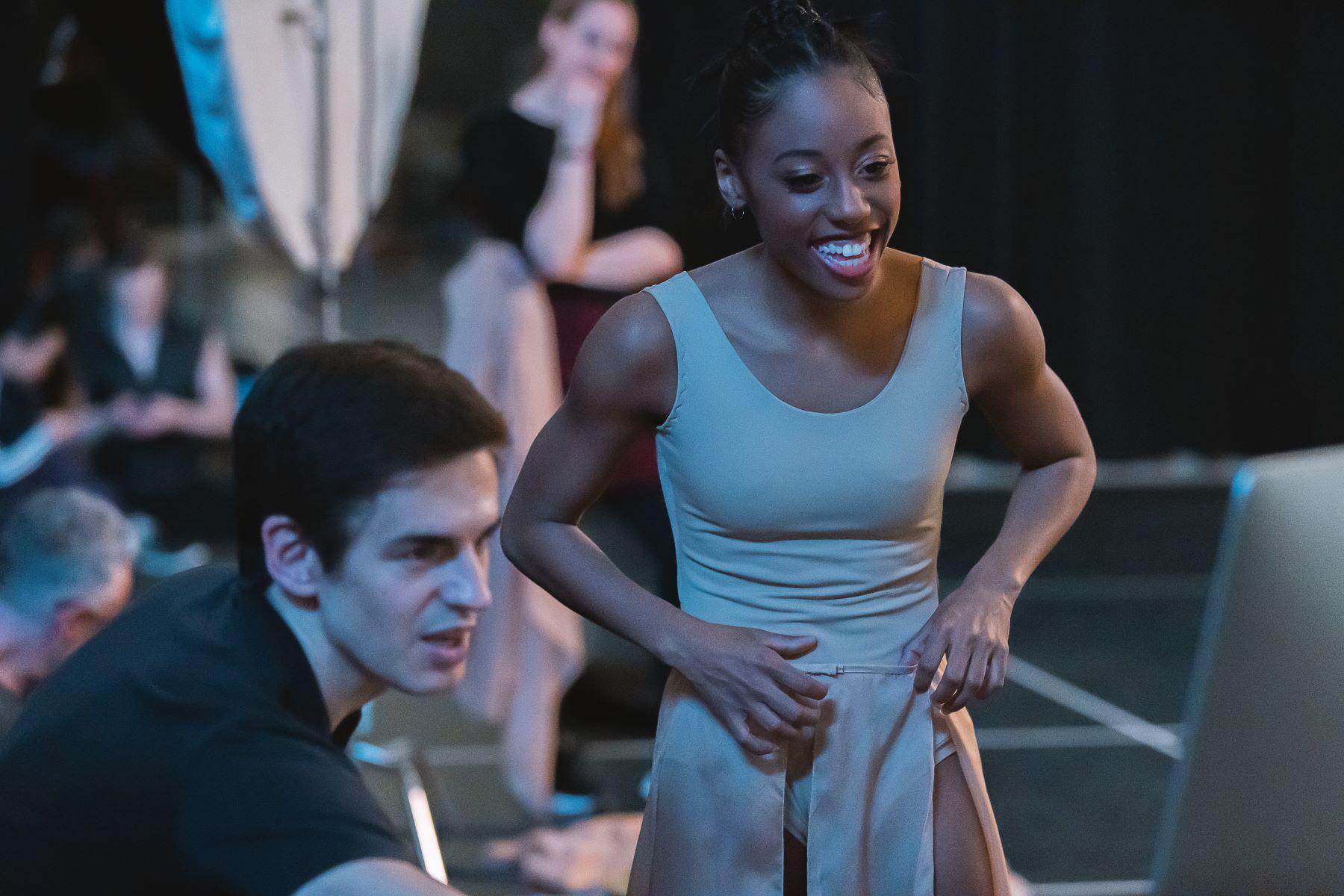 A mana and woman smile as they look at a computer screen
