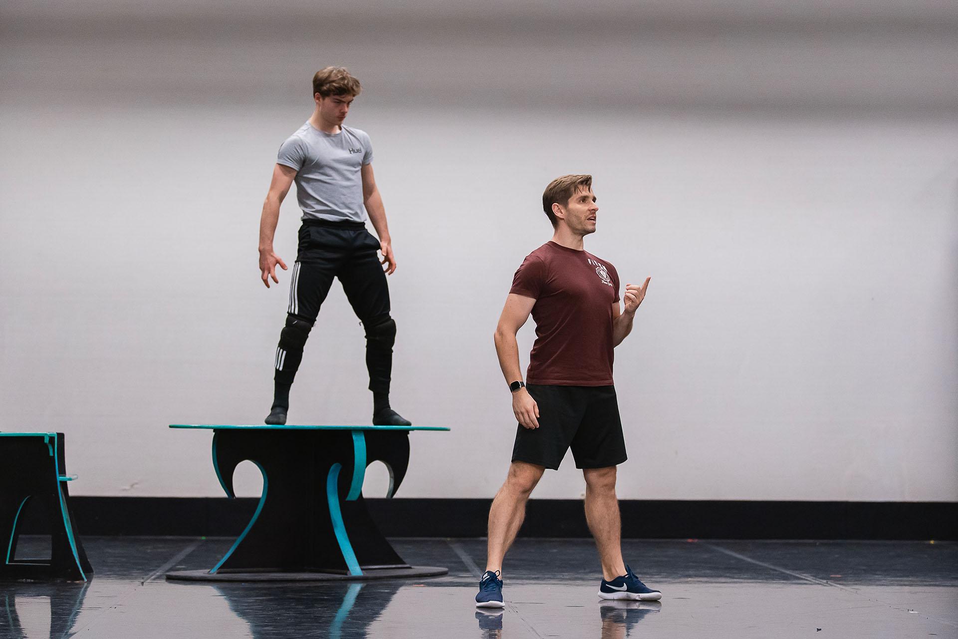 Dancer menacingly stands on a table following instruction as he rehearses the role of the Beast.