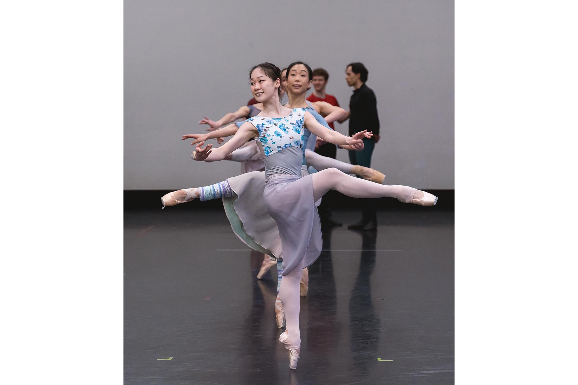 Dancers stood in a line on one foot