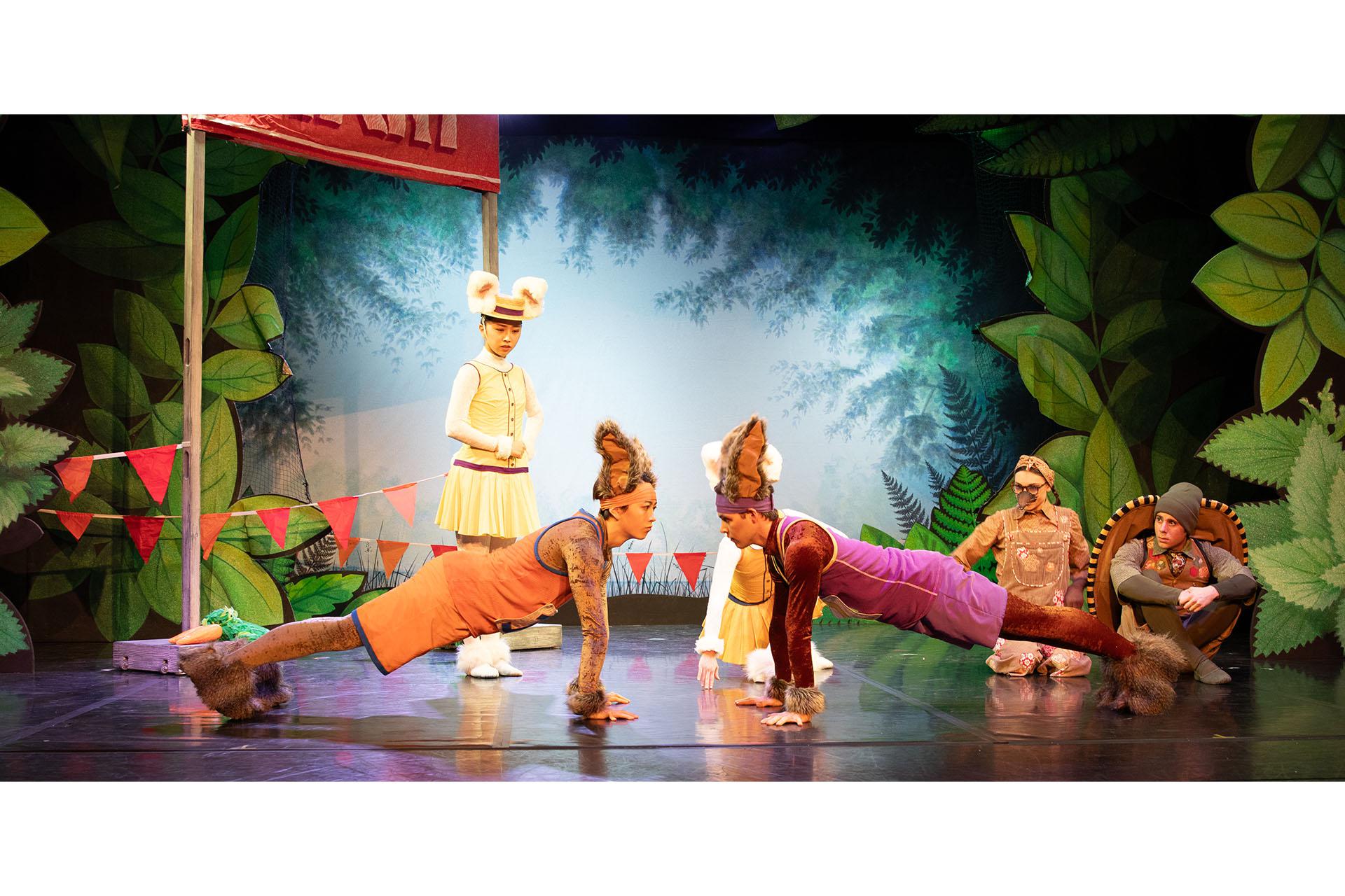 Dancers in bunny costumes, preparing for the race facing each other in a plank position