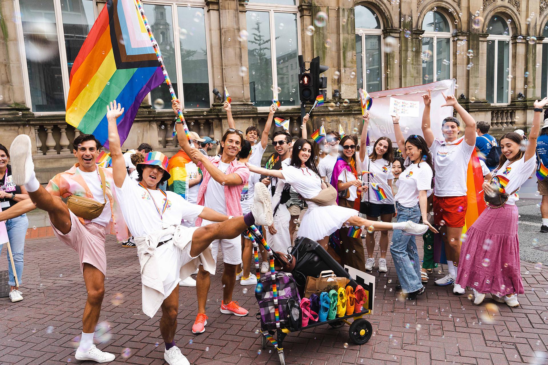 Northern Ballet dancers at Leeds Pride 2024 in rainbow flags, white tutus, and broad smiles