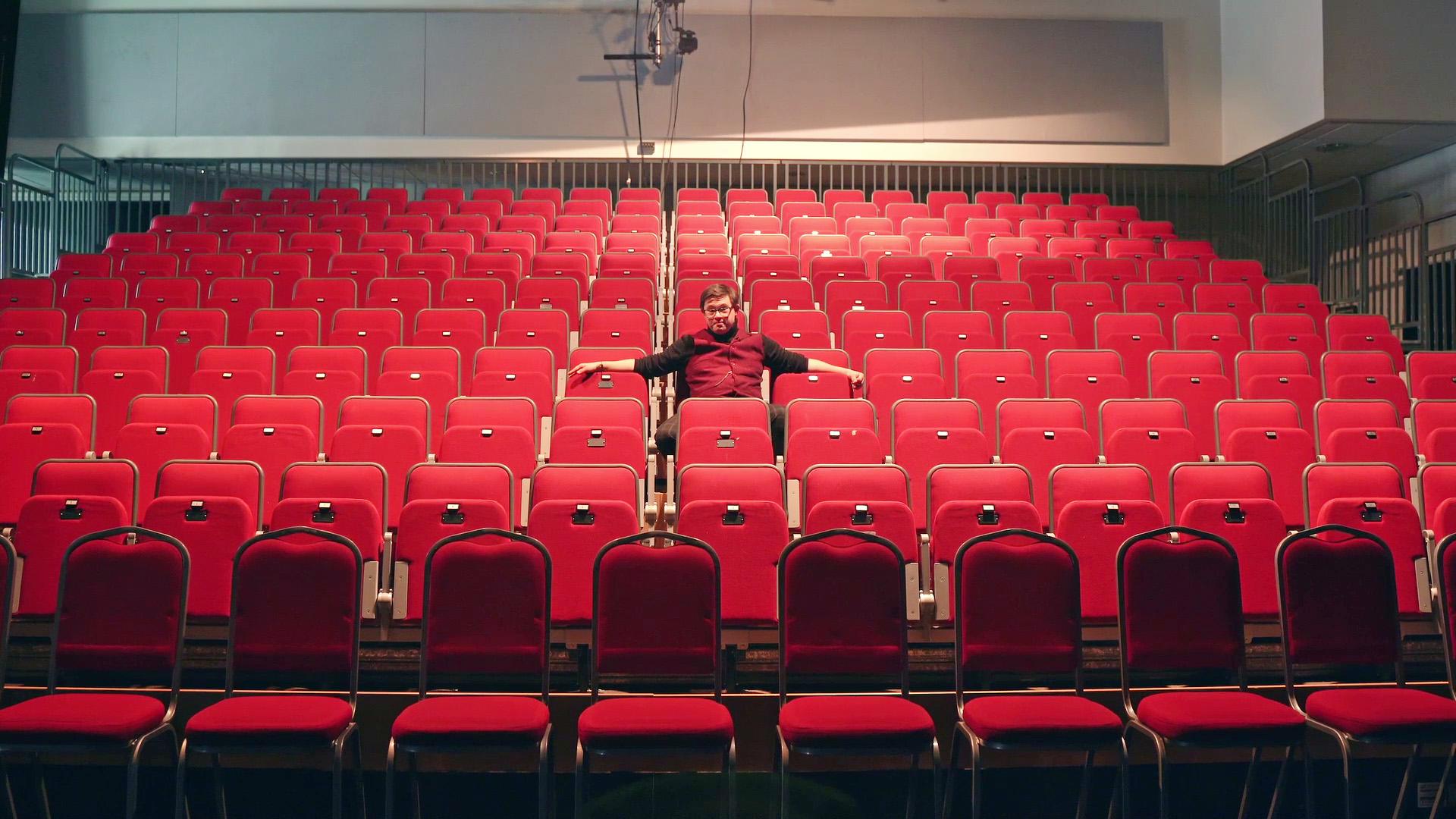 A man is sat on the seats in the Northern Ballet auditorium