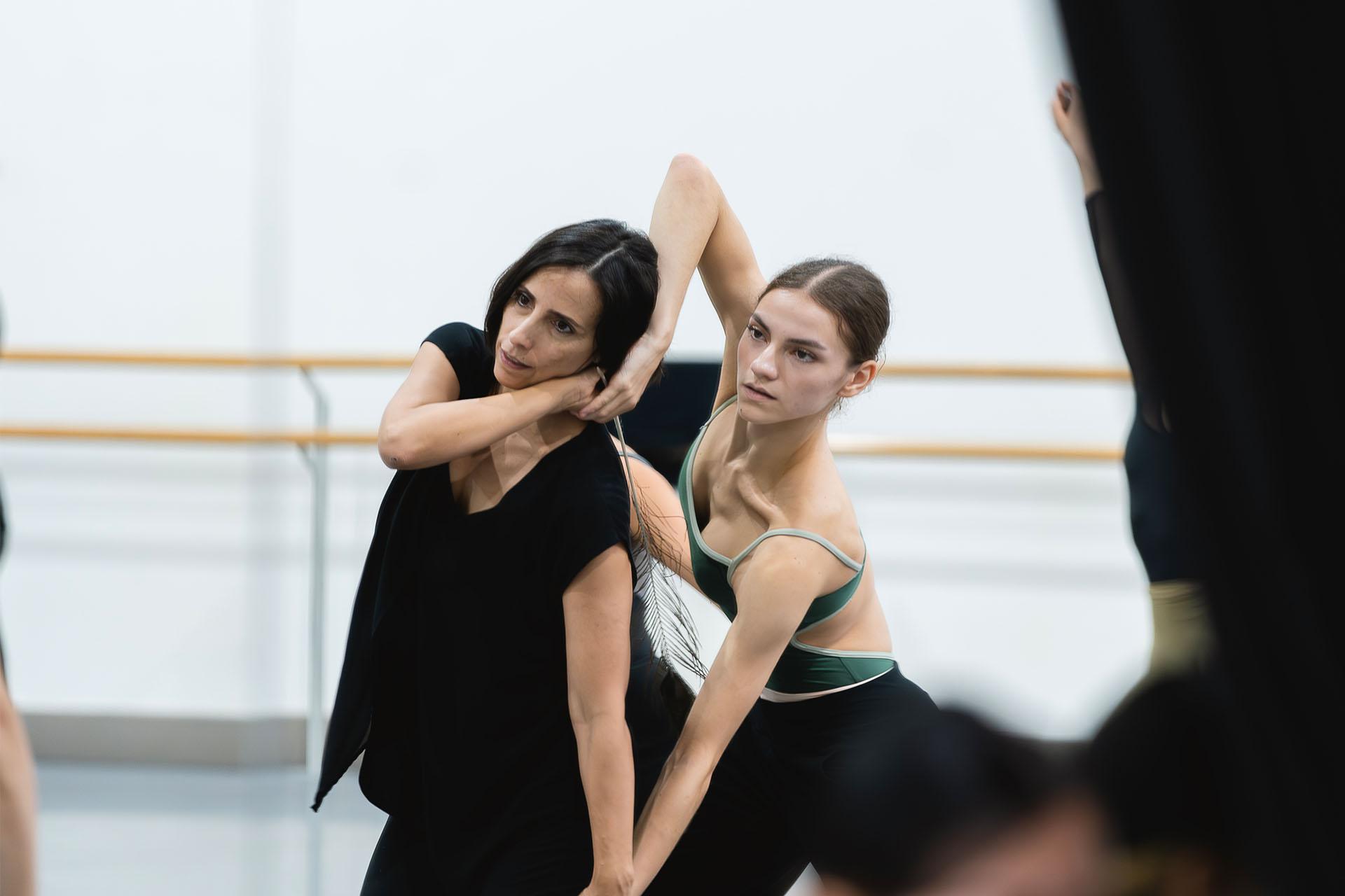 Choreographer in black partnering with dancer to show moves