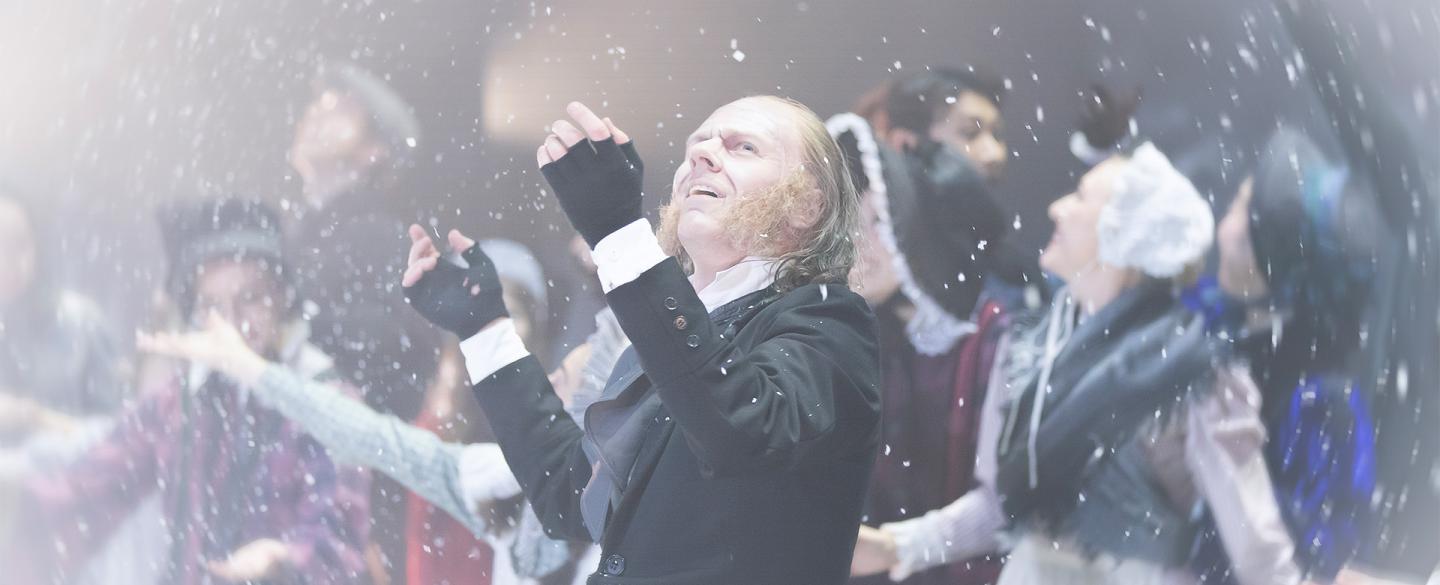 A dancer in Dickensian costume stood on stage marvelling at the snow falling