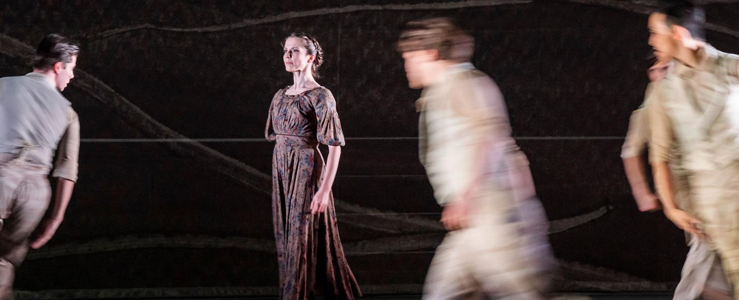 Jane Eyre slowly moves across stage contemplatively, those moving around her are in a blur