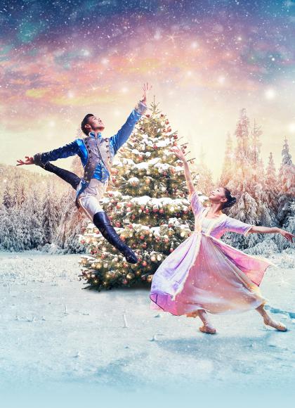 Clara and the Nutcracker Prince dancing in the snow in front of a Christmas tree