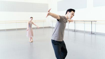 One dancer in the background follows the movements of another in the foreground