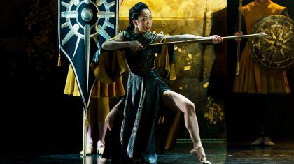 Knees bent and holding a pike ready for battle, Morgan is dressed in black